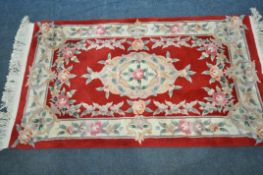 A RED GROUND CHINESE RUG, with floral design, 153cm x 90cm (good condition)