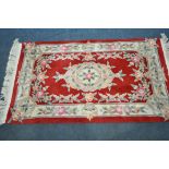 A RED GROUND CHINESE RUG, with floral design, 153cm x 90cm (good condition)