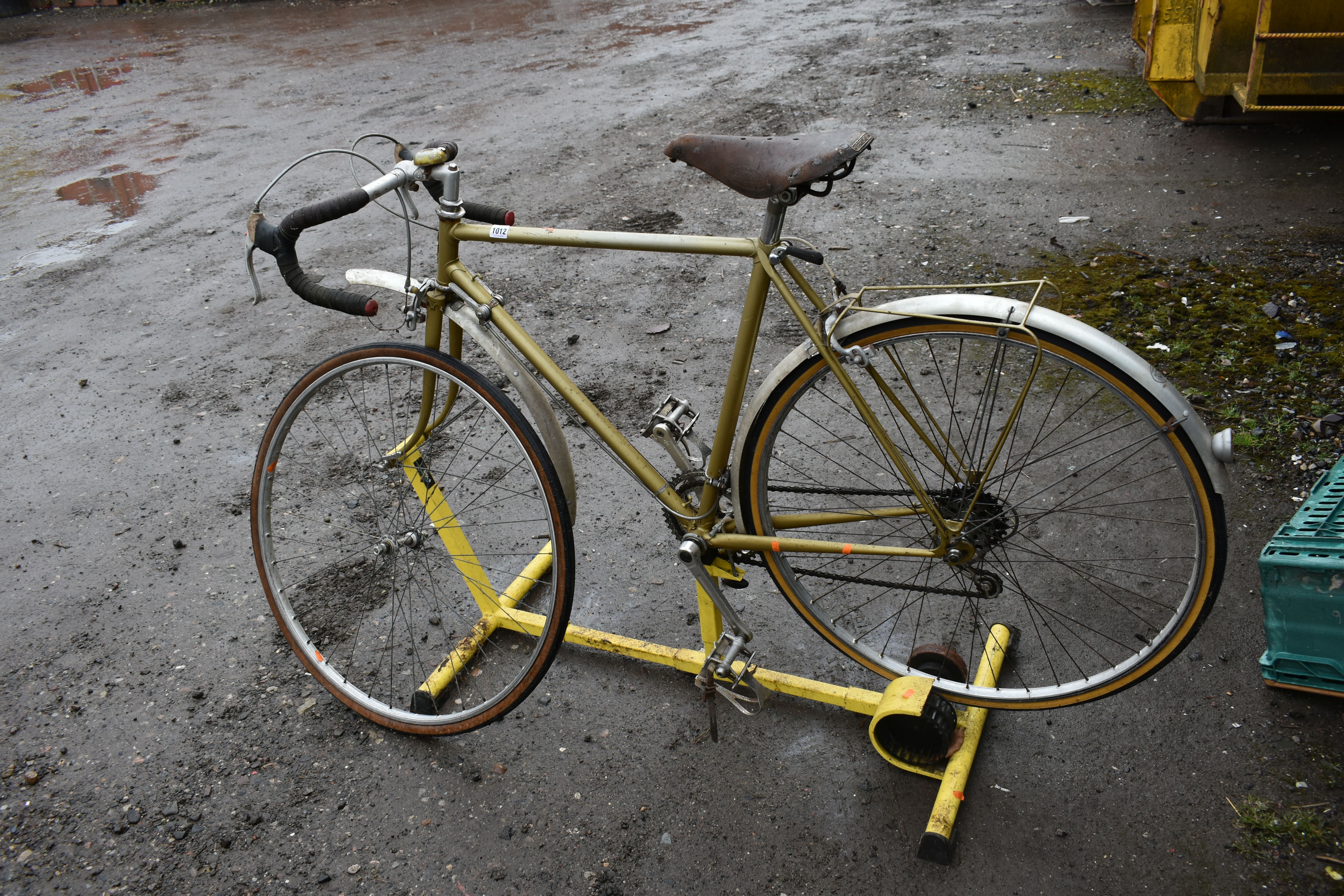 A VINTAGE RACING BIKE STAMPED C.B. LONDON TO FRONT BADGE mounted to an Ultech static frame, front