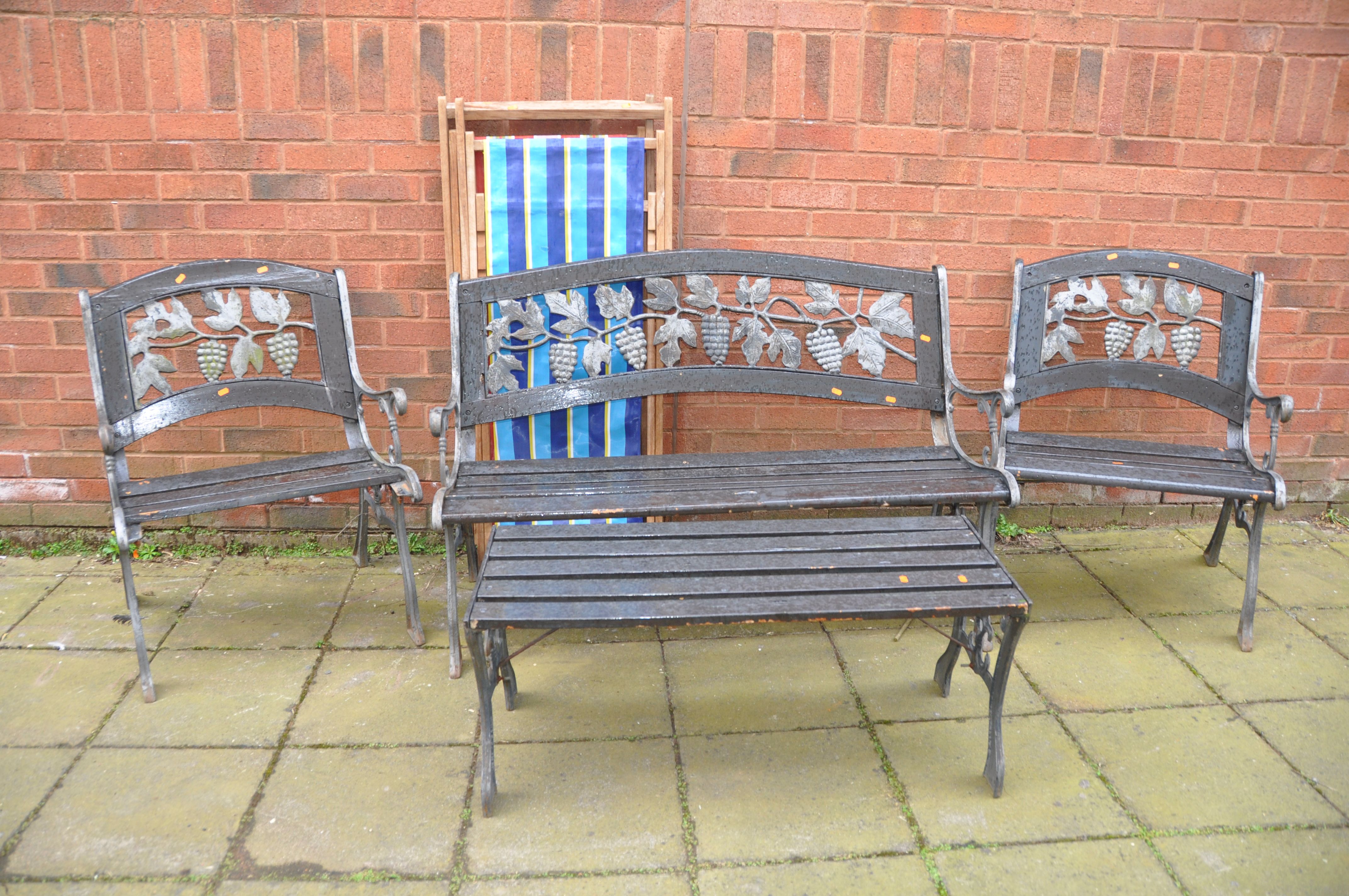 A FOUR PIECE CAST METAL AND SLATTED GARDEN SUITE, comprising a garden bench, two matching armchairs,