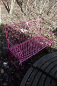A PINK PAINTED WROUGHT IRON GARDEN BENCH, with floral decoration, length 114cm (condition:-
