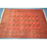 A LARGE AFGHAN RED GROUND RUG, with twenty four medallions, 300cm x 207cm (condition:-tassels worn