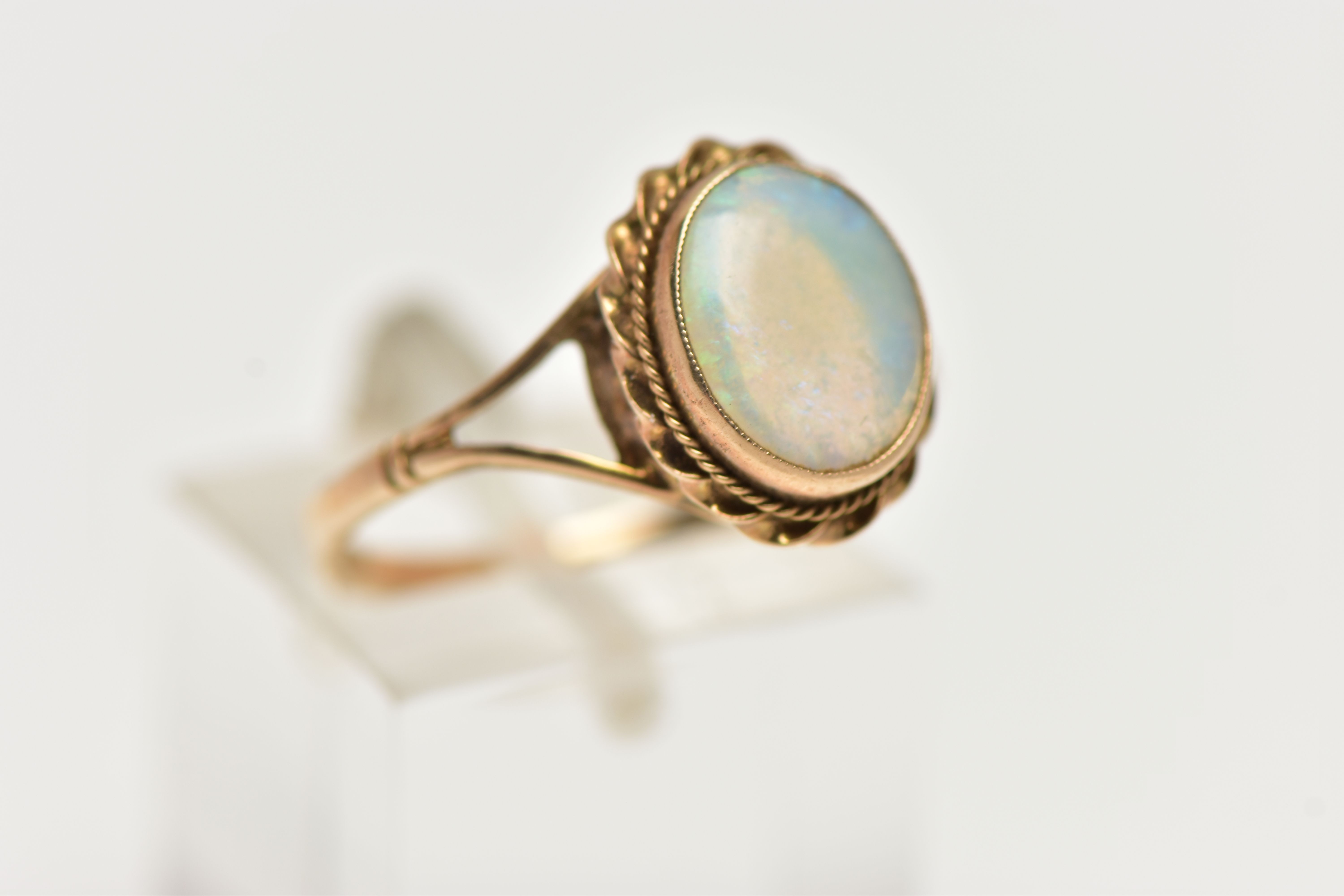 A 9CT GOLD OPAL RING, designed with an opal cabochon, in a milgrain collet setting, to a rope - Image 4 of 4