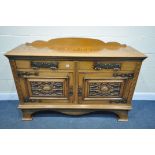 AN ARTS AND CRAFTS OAK SIDEBOARD, with a raised back, the two drawers and double cupboard doors with