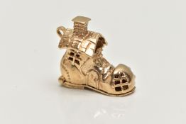 A 9CT GOLD CHARM, yellow gold charm of a boot house, fitted with a hinged sole, opens to reveal