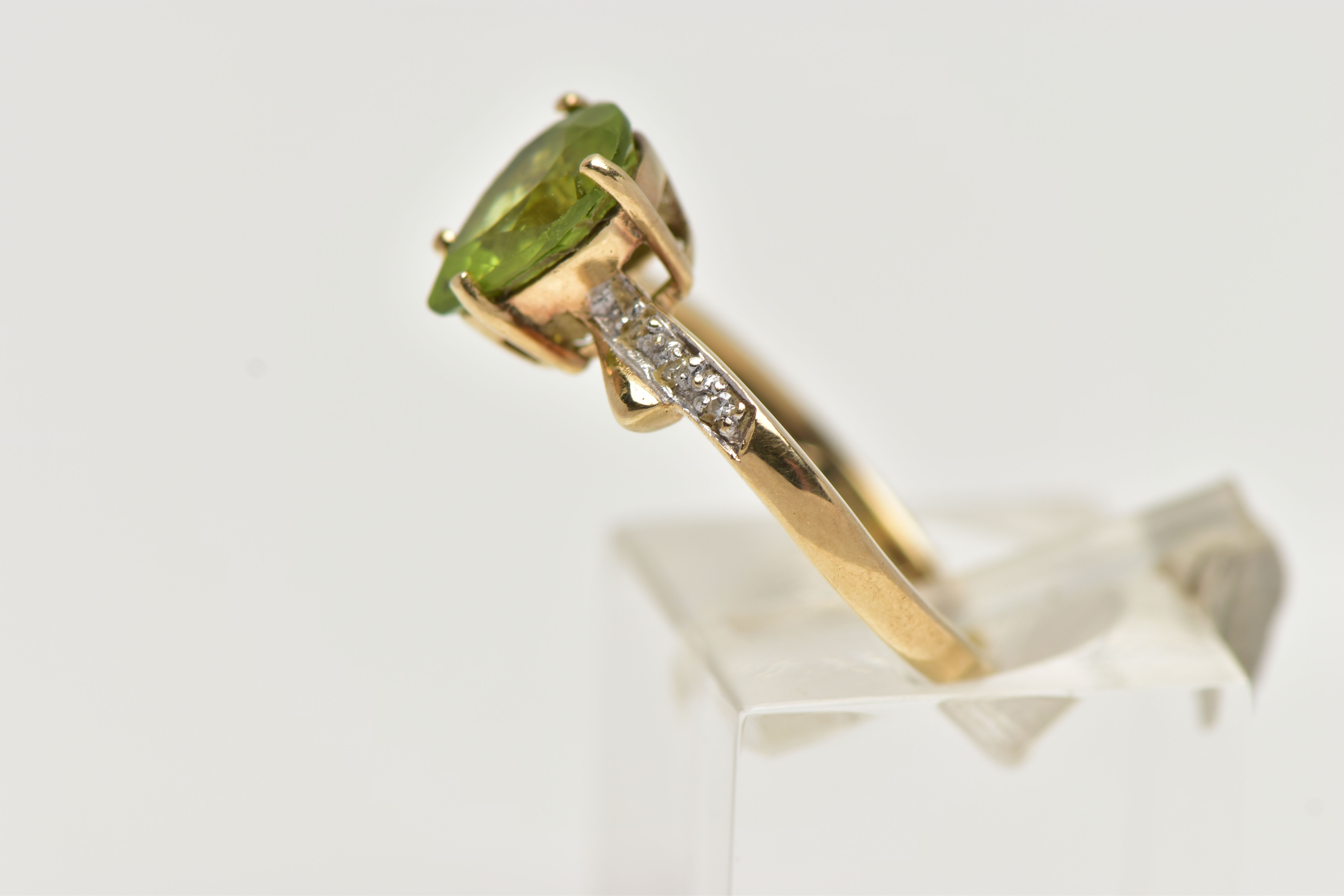 A 9CT GOLD, PERIDOT AND DIAMOND RING, designed with a four claw set, pear cut peridot, flanked - Image 2 of 4