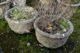 A PAIR OF WEATHERED COMPOSITE CIRCULAR PLANTERS, with a floral design, diameter 53cm x height