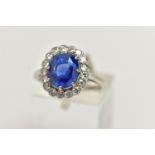 A SAPPHIRE AND DIAMOND CLUSTER RING, set with a mixed cut, cushion sapphire, measuring approximately