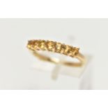 A 9CT GOLD CITRINE RING, designed with a row of seven circular cut citrines, to the polished band,
