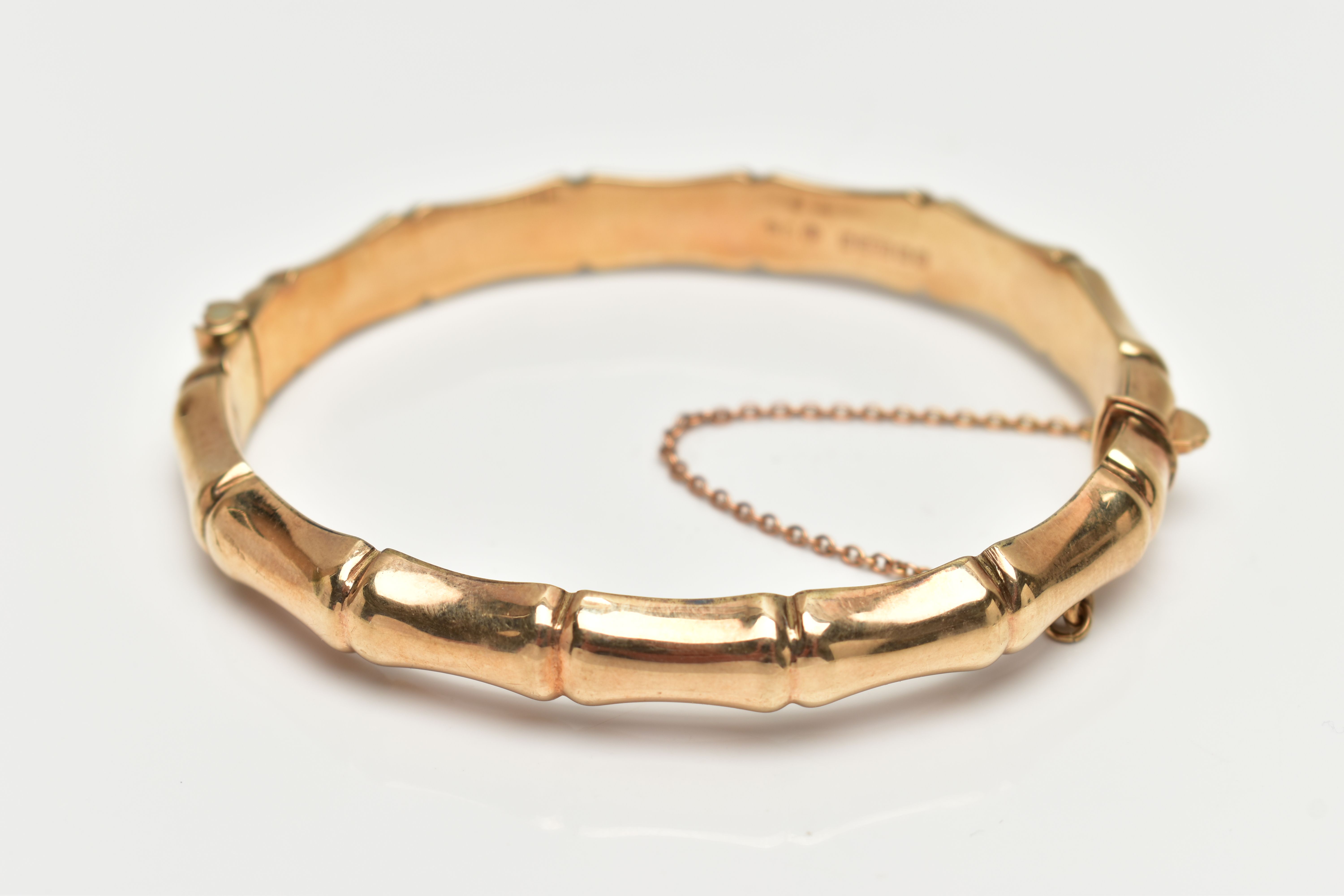 A 9CT GOLD 'SMITH & PEPPER' BANGLE, a yellow gold bamboo style hollow hinged bangle, fitted with - Image 2 of 3