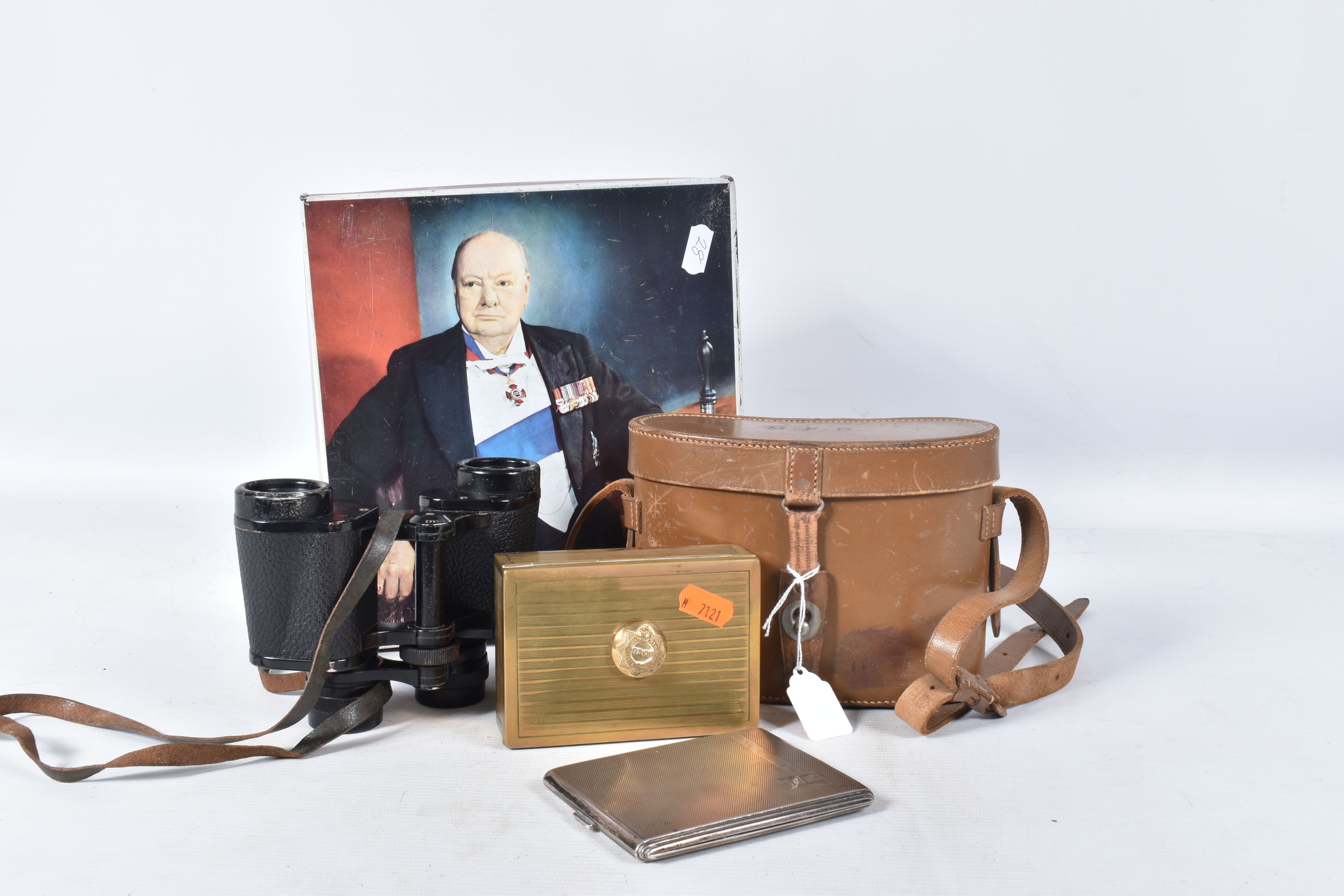 A WINSTON CHURCHILL BISCUIT TIN, containing a hallmarked silver cigarette holder, a cased set of