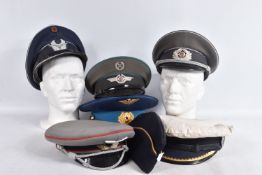SIX MILITARY PEAKED CAPS AND A SIDE CAP, to include three Russian style caps, two German caps that