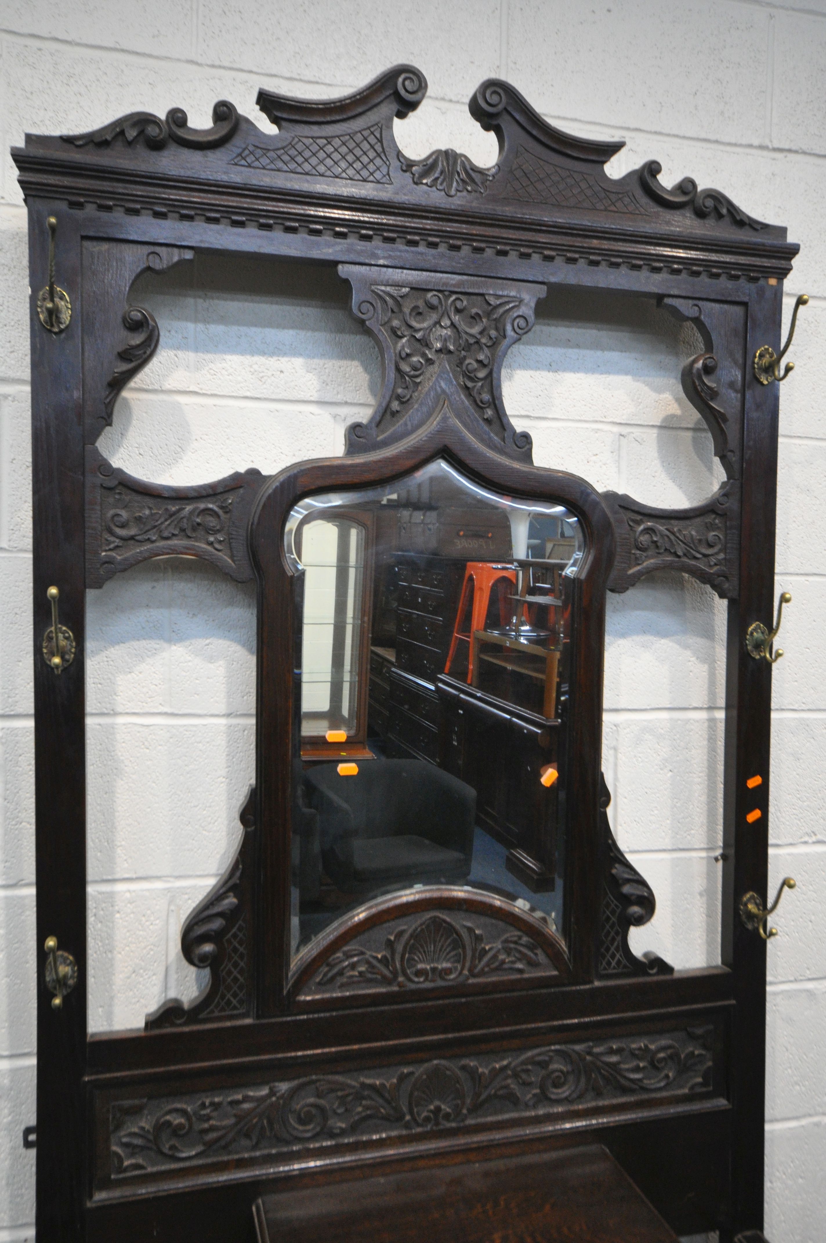 A LATE 19TH CENTURY CARVED OAK HALL STAND, with six brass coat hooks, central shaped bevelled edge - Image 2 of 3