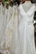 A GROUP OF NINE WEDDING DRESSES AND ONE PINK BRIDESMAID DRESS, retail stock clearance, varying UK