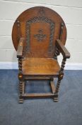A 20TH CENTURY OAK MONKS CHAIR, the circular top with carving to the underside, barley twist legs
