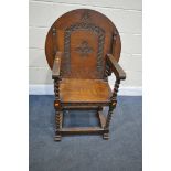 A 20TH CENTURY OAK MONKS CHAIR, the circular top with carving to the underside, barley twist legs