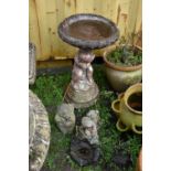 A MODERN COMPOSITE BIRD BATH in the form of a small child seated on a rock pile holding a bowl (
