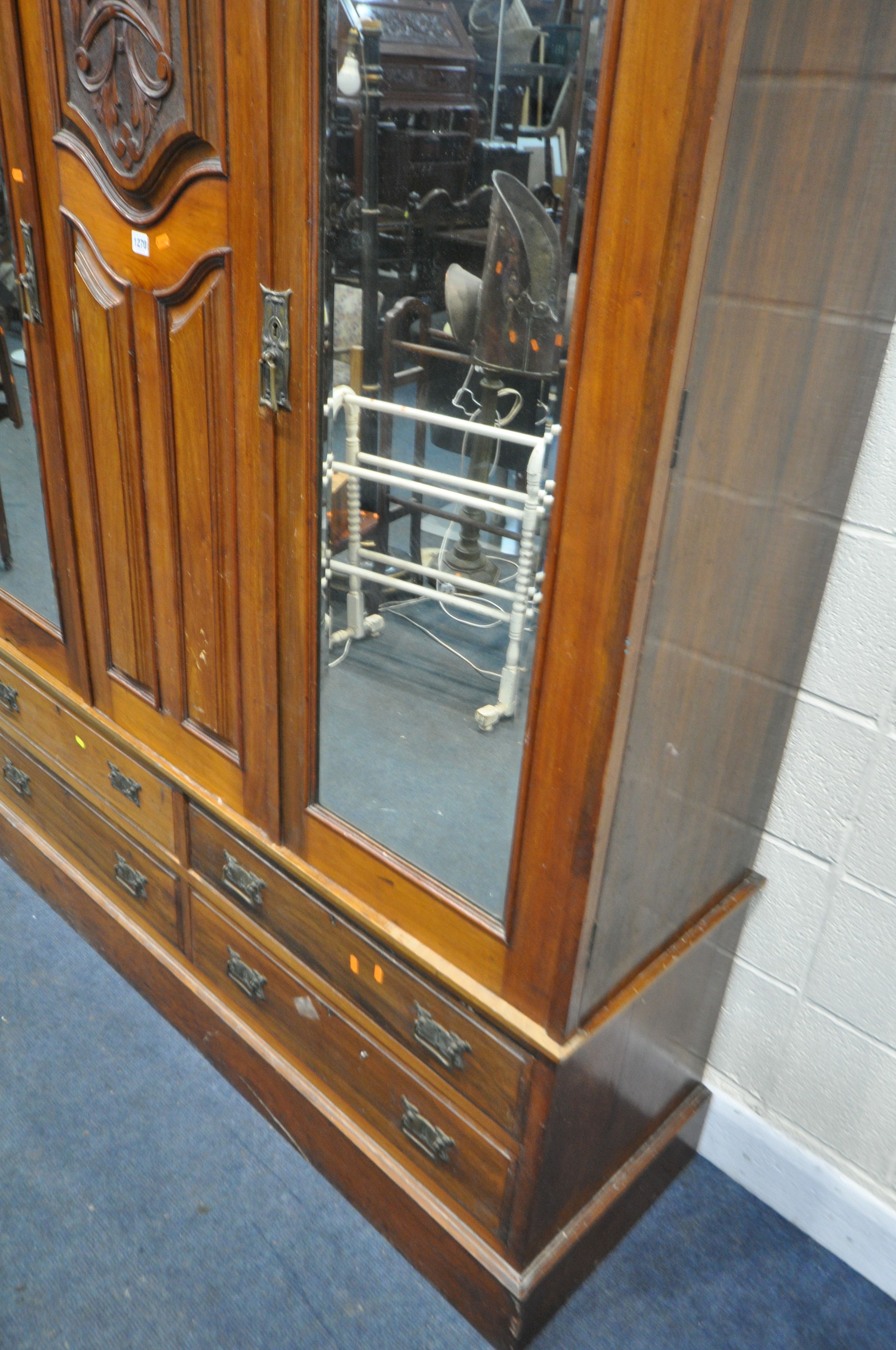 AN EDWARDIAN WALNUT WARDROBE, with two bevelled mirror doors that's flanking a fixed panel, over - Image 4 of 5