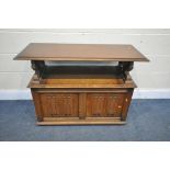 A 20TH CENTURY OAK MONKS BENCH, with hinged lid and storage compartment, with lion arm supports,