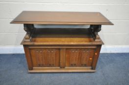 A 20TH CENTURY OAK MONKS BENCH, with hinged lid and storage compartment, with lion arm supports,