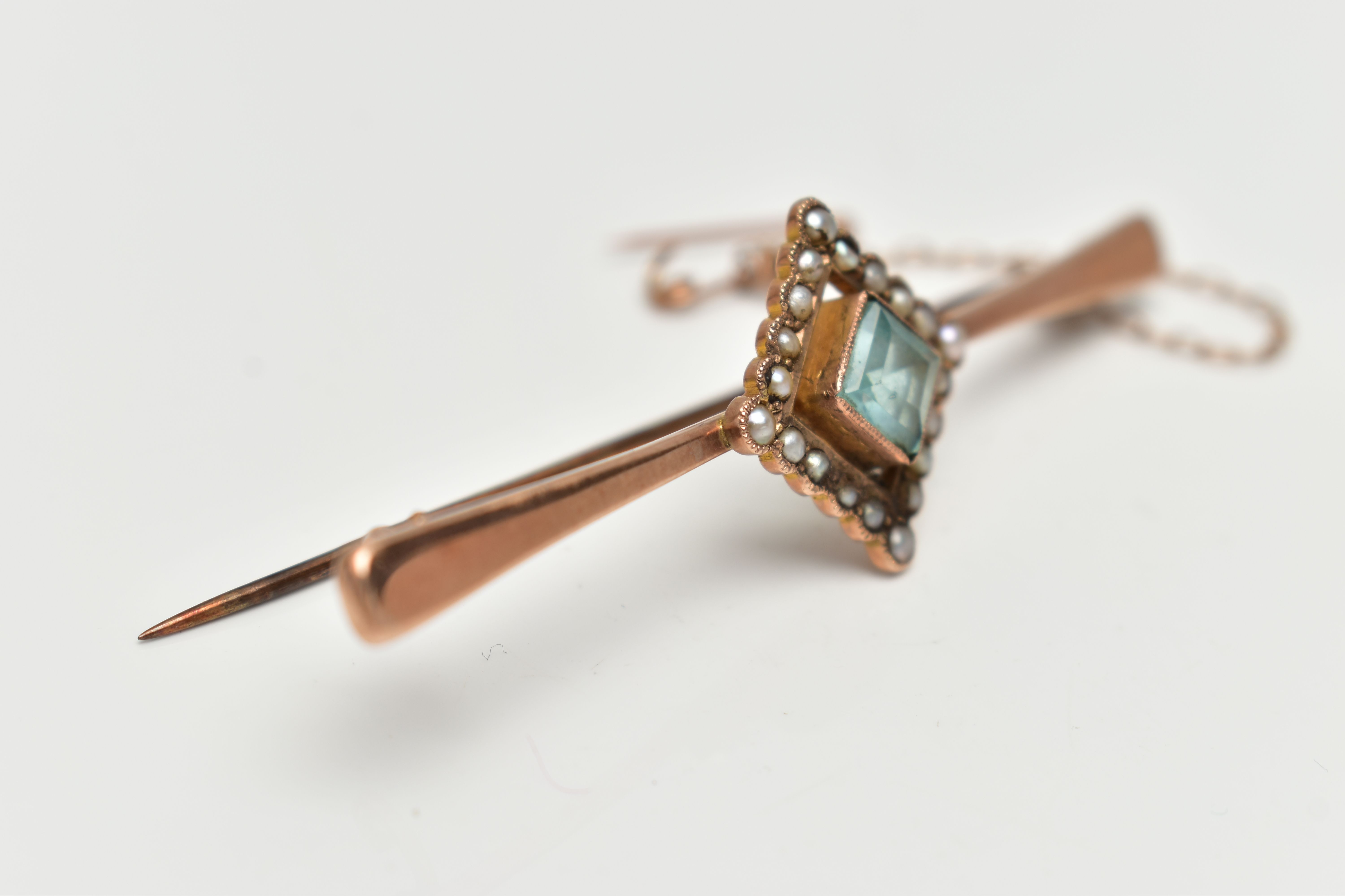 A ROSE METAL, GEM SET BAR BROOCH, tapering polished bar, displaying a square cut pale blue stone - Image 2 of 4