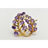 A YELLOW METAL AMETHYST 'LOTOS' SPRAY BROOCH, foliage spray design set with eighteen oval cut