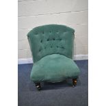 A VICTORIAN BEDROOM CHAIR, reupholstered in green buttoned fabric, on turned front legs and brass