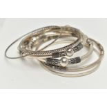 SEVEN WHITE METAL BANGLES, to include two with bead and rope twist patterns, unmarked, a thin bangle