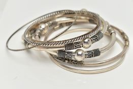 SEVEN WHITE METAL BANGLES, to include two with bead and rope twist patterns, unmarked, a thin bangle