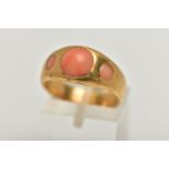 A YELLOW METAL CORAL RING, designed with three circular cut coral cabochon inlayed to a yellow metal