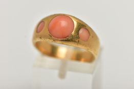 A YELLOW METAL CORAL RING, designed with three circular cut coral cabochon inlayed to a yellow metal