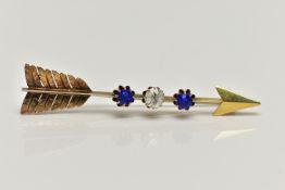 A YELLOW METAL GEM SET ARROW BROOCH, polished arrow brooch with textured feathers, set with an old
