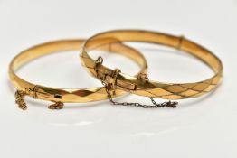 TWO YELLOW METAL BANGLES, the first a hinged bangle with a faceted design, stamped 'gold metal