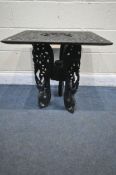 AN EBONISED ANGLO-INDIAN CARVED HARDWOOD SQUARE TOP TABLE, on a triple legged base, 61cm squared x