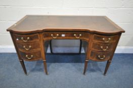 AN EDWARDIAN MAHOGNY AND CROSSBANDED KNEE HOLE DESK, with a brown leather writing surface, nine