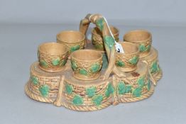 A NINETEENTH CENTURY MAJOLICA STAND CONTAINING SIX EGG CUPS, the stand of lobed form with twisting