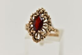 A 9CT GOLD GARNET RING, of an openwork marquise outline, set to the centre with a marquise cut