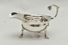 A GEORGE III SMALL SILVER SAUCE BOAT OF SHAPED OVAL FORM, 'S' scroll handle, wavy rim, on three