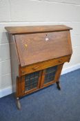 ARTS AND CRAFTS OAK SHALLOW BUREAU, with single over double lead glassed doors, width 82cm x depth