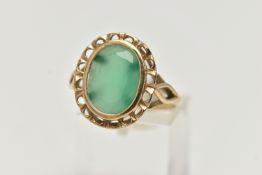 A 9CT GOLD GREEN CHALCEDONY RING, of an oval form, collet set within an openwork surround,