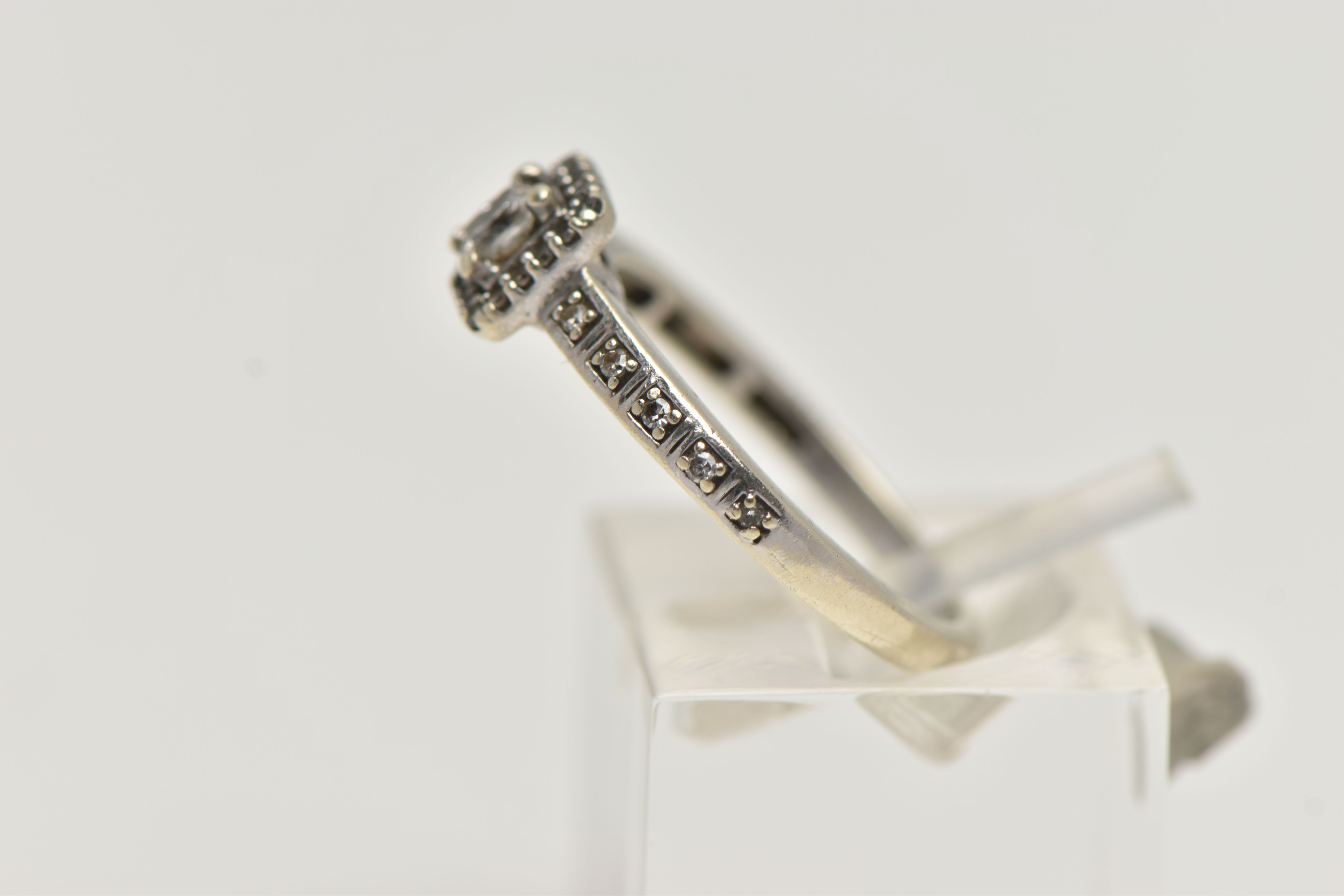 A 9CT WHITE GOLD DIAMOND CLUSTER RING, square head set with an emerald cut diamond, in a surround of - Image 2 of 4
