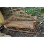 A MODERN HARDWOOD GARDEN BENCH with slatted seat, back and arms, scrolled design to arms width
