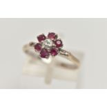 A YELLOW METAL, DIAMOND AND RUBY CLUSTER RING, flower cluster set with a central round brilliant cut