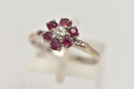 A YELLOW METAL, DIAMOND AND RUBY CLUSTER RING, flower cluster set with a central round brilliant cut