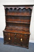 A TITCHMARSH AND GOODWIN STYLE OAK DRESSER, the top with a wavy apron, two shelves and four drawers,