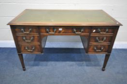 A REPRODUCTION MAHOGANY WRITING DESK, with a green leather writing surface, seven drawer, on