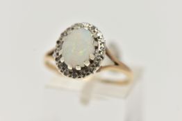 A 9CT GOLD OPAL AND DIAMOND CLUSTER RING, centring on an oval opal cabochon, claw set in a