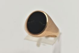 A GENTS 9CT GOLD ONYX SIGNET RING, of an oval design set with a polished onyx inlay (two cracks), to