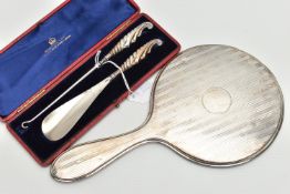 A CASED LATE VICTORIAN SILVER HANDLED BUTTON HOOK AND SHOE HORN AND A SILVER BACKED HAND MIRROR, the