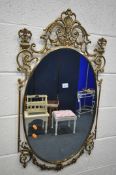 A GILT METAL WALL MIRROR, with a scrolled frame and an oval plate, 51cm x 94cm